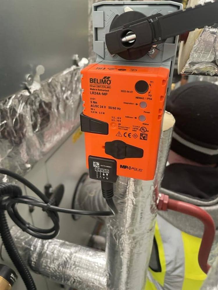 Close-up view of Belimo LR24A-MP Rotary Actuator connected to HVAC ductwork, highlighting advanced control features and MP-Bus connectivity for efficient air handling operation.